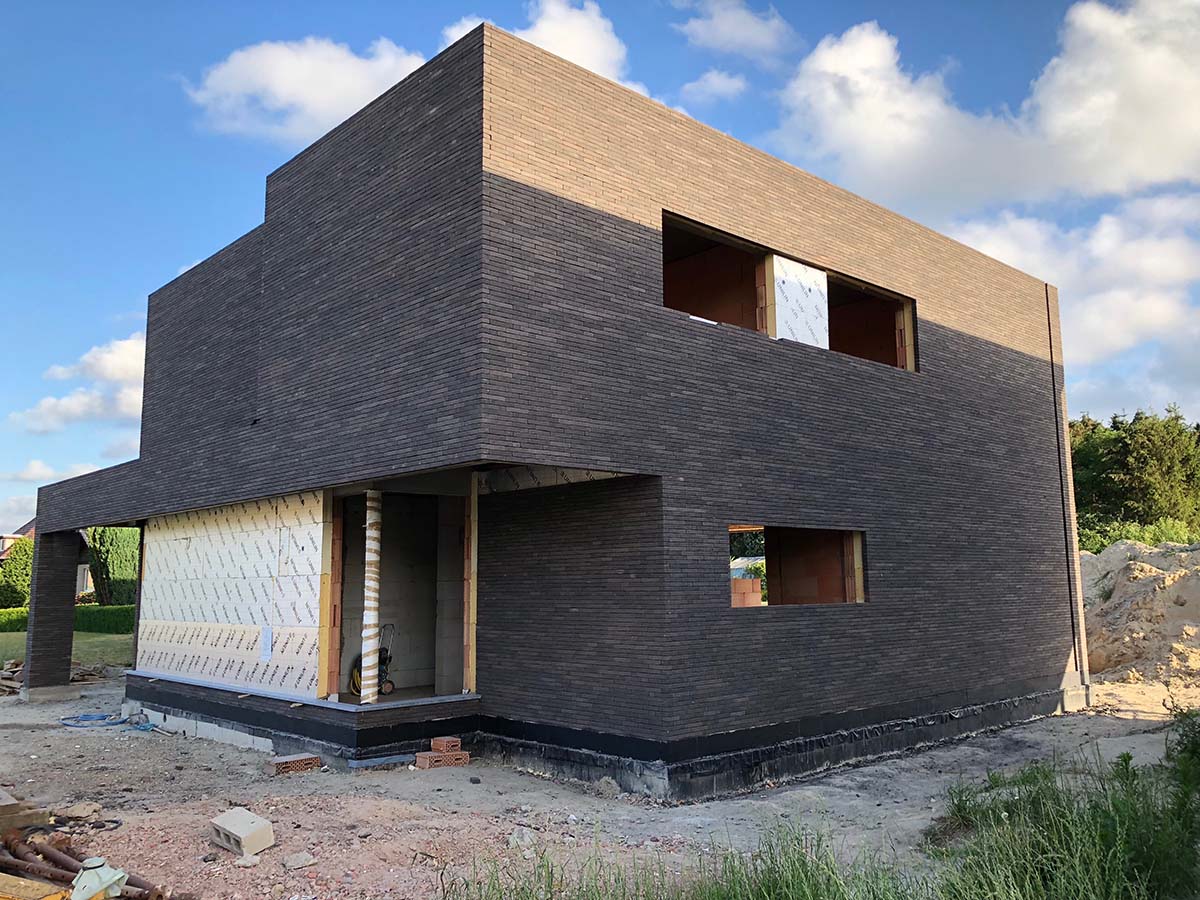 Tall slender porcelain bottle with natural clay textured body and cork stopper.