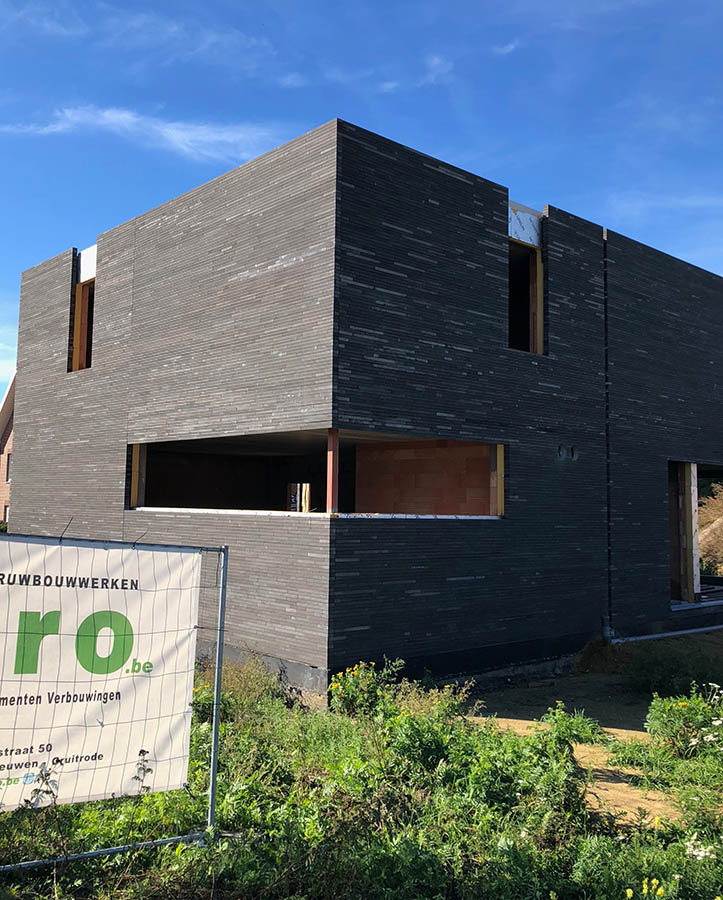 Tall slender porcelain bottle with natural clay textured body and cork stopper.